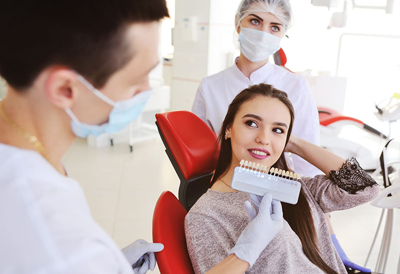 Dentista Valorando el Tono de la Carilla para su Paciente
