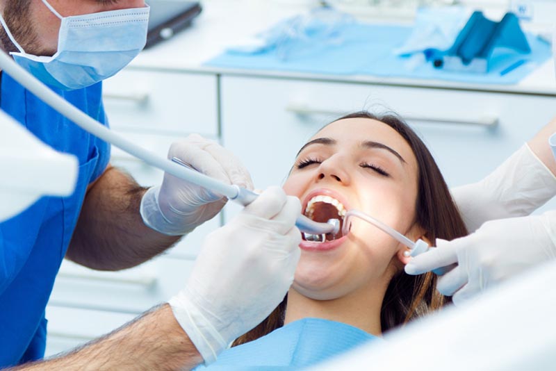 Dentista realizando una endodoncia a una paciente