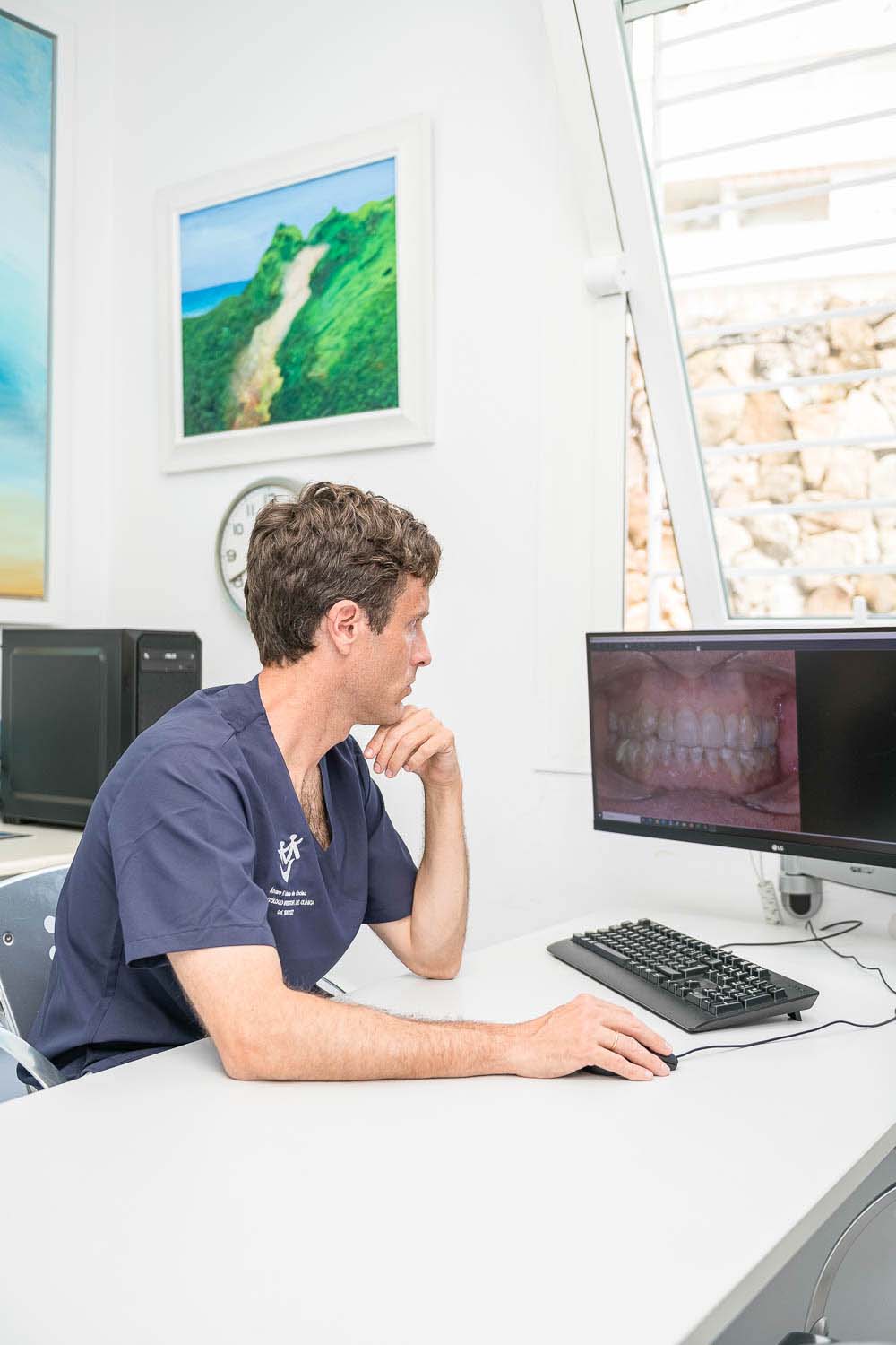 Dr. Lobato trabajando en el ordenador en el caso de un paciente